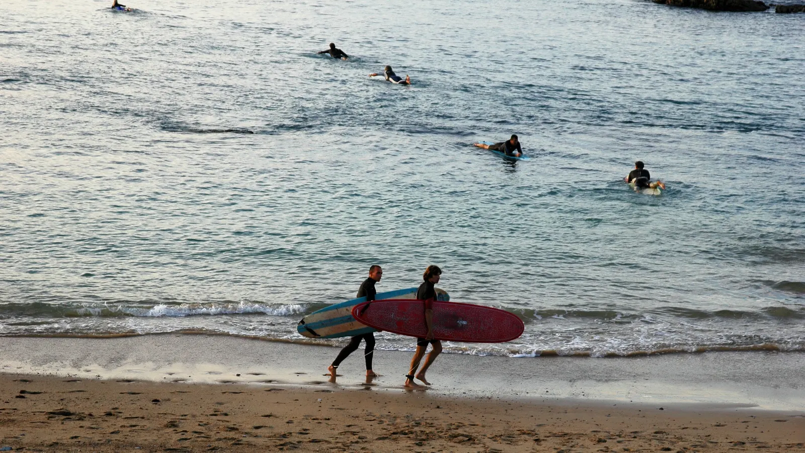 Deux surfeurs sur la plage de Guéthary, planche sous le bras