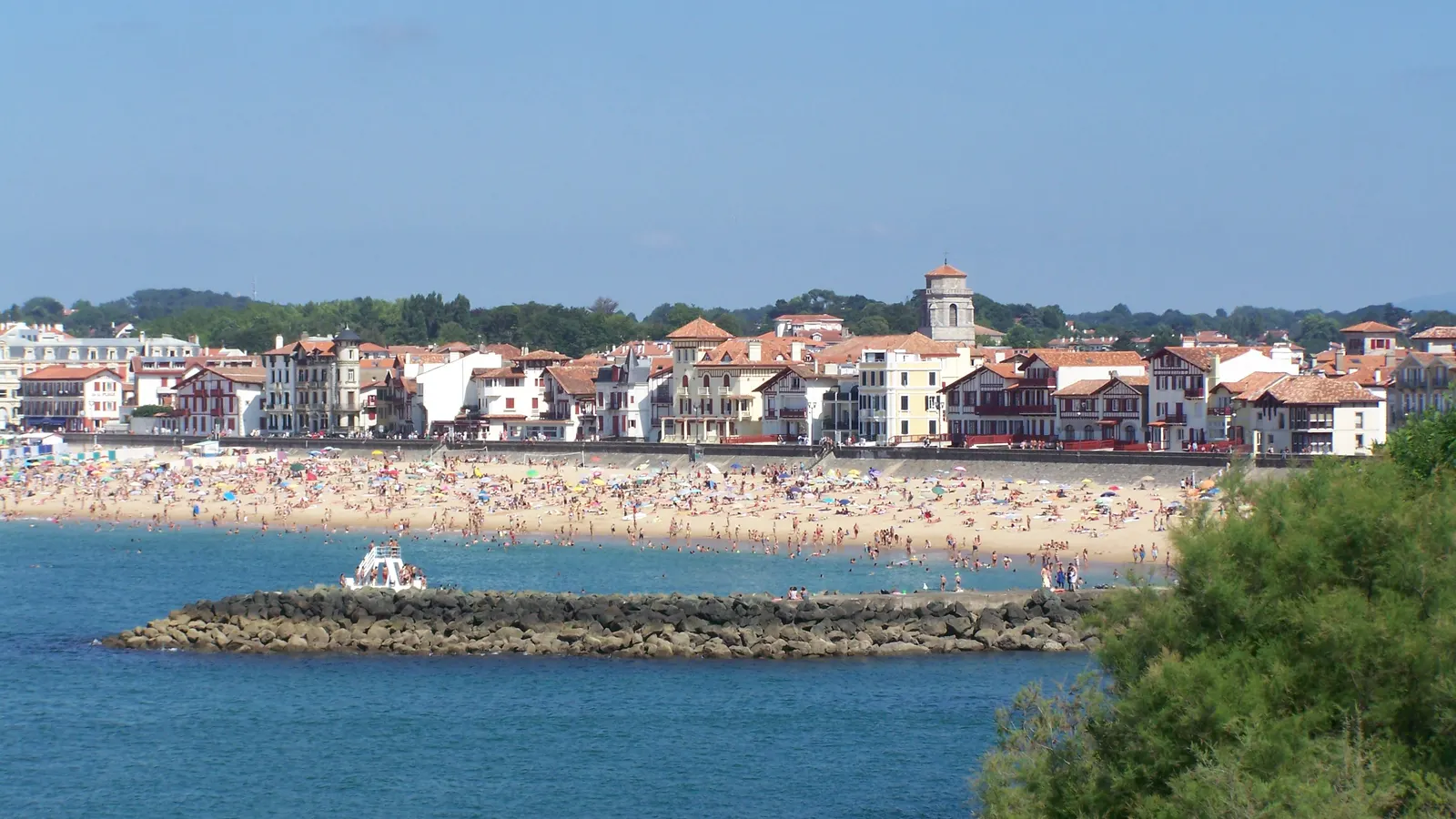 La baie de Saint-Jean-de-Luz, sa grande plage et les maisons du front de mer sous un ciel bleu