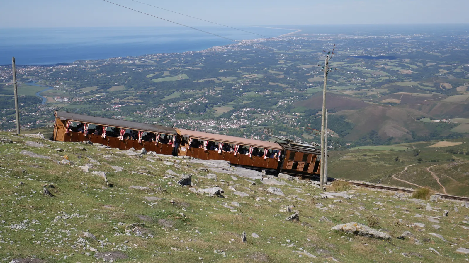 Le petit train de la Rhune dans la descente, avec la côte basque en arrière-plan